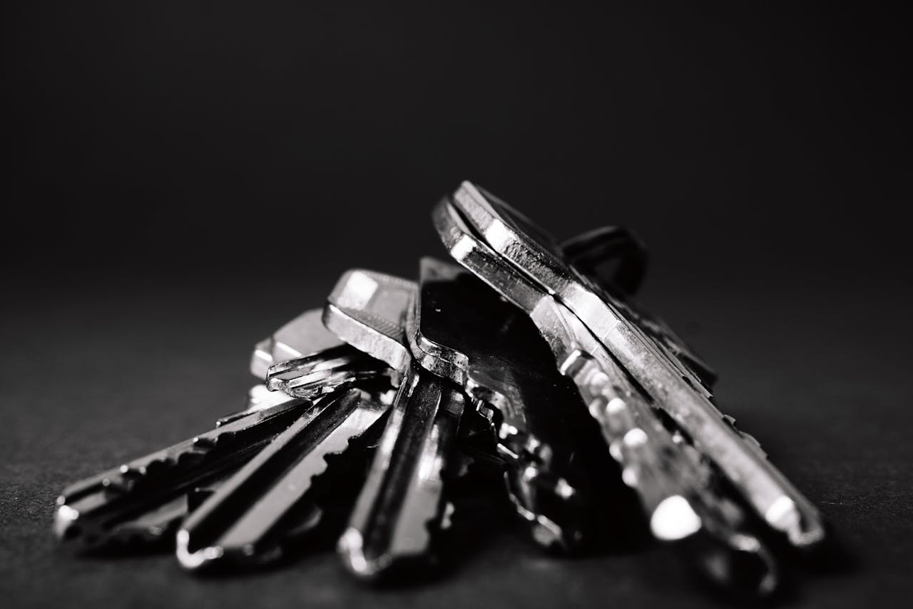 About A close-up shot of a pile of metallic keys on a dark surface, emphasizing security and precision.